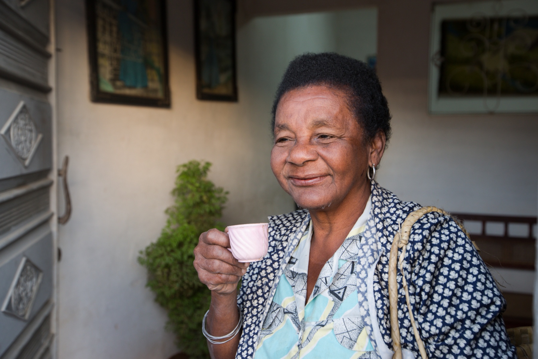smiling older Black woman holding a tea cup